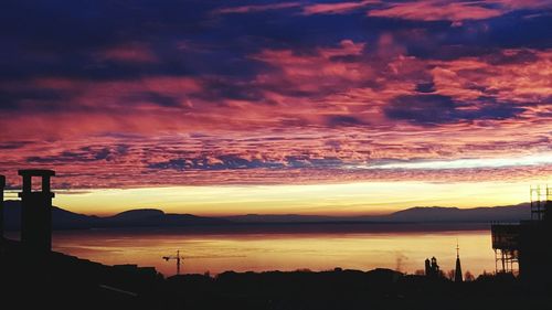 Silhouette of mountain against cloudy sky at sunset