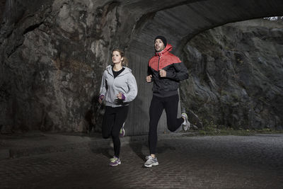 Sporty couple jogging in tunnel