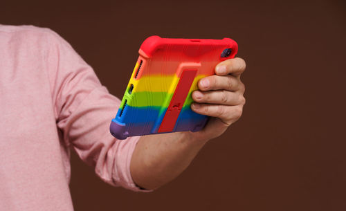 Midsection of man holding container against black background