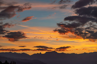 Low angle view of silhouette mountains against romantic sky