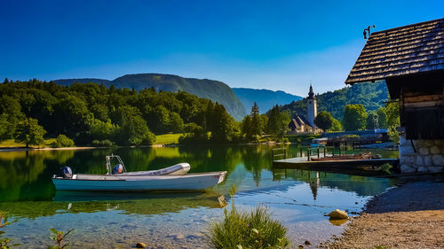 Scenic view of lake and trees against blue sky