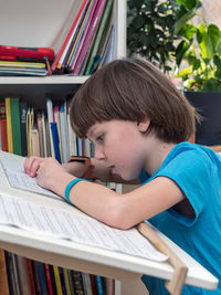 Side view of boy studying at home