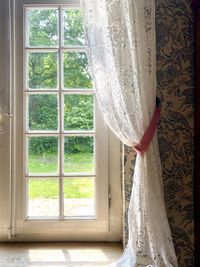 White curtain hanging on window sill at home