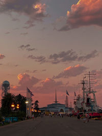 Illuminated city against sky at sunset