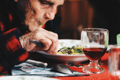 Close-up of man holding beer glass on table