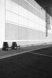 Empty bench on wall by building