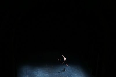 Shirtless man performing ballet dance on stage