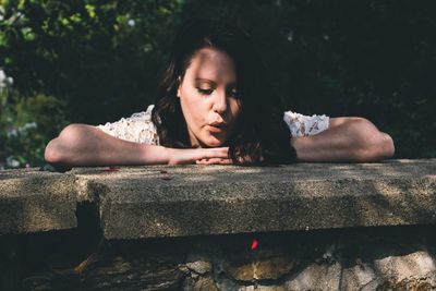 Close-up of young woman in retaining wall in park