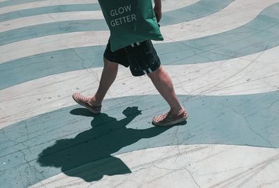 Low section of woman walking on footpath