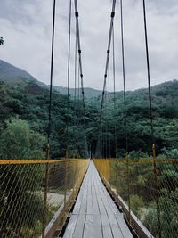 View of footbridge over sea against sky