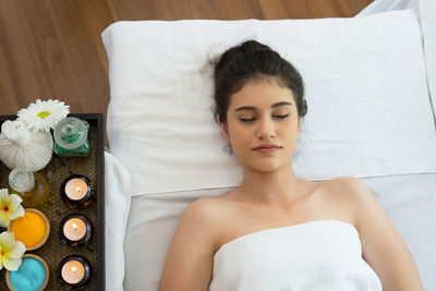 Young woman relaxing on massage table in spa