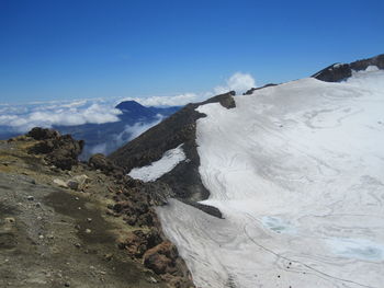 Scenic view of snowcapped mountains against blue sky