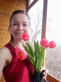 Portrait of woman holding pink rose