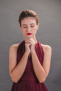 Close-up of young woman against gray background