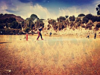 Children playing on landscape against sky