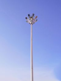 Low angle view of floodlight against blue sky