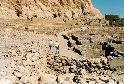 Rear view of female friends walking at old ruins