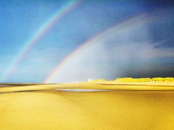 Scenic view of rainbow over sea against sky