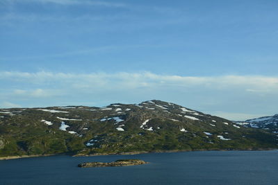 Scenic view of lake by mountain against sky