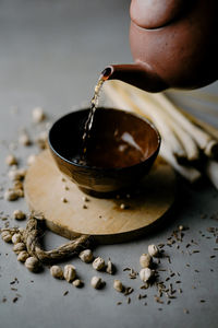 Close-up of hand pouring coffee cup