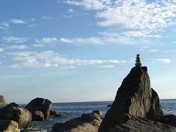 Rock formation on beach against sky