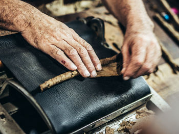 Close-up of manual worker making cigar in factory