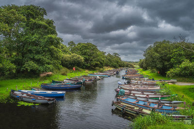 Boats moored in water against sky