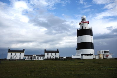 Low angle view of lighthouse amidst buildings against sky