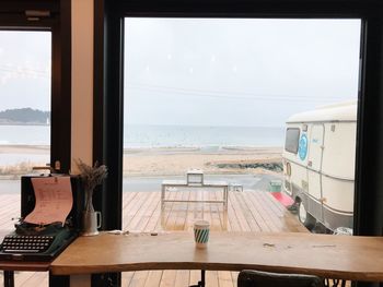 Chairs and table at beach against sky