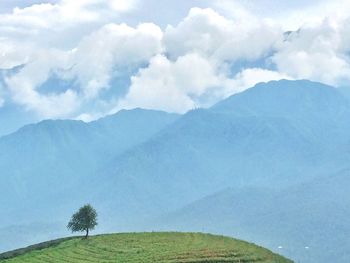 Scenic view of mountains against cloudy sky