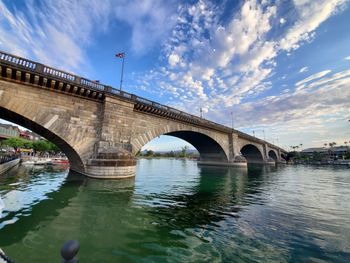 Arch bridge over river against sky