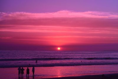 People at beach during sunset