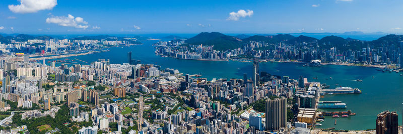 Aerial view of city by bay against sky