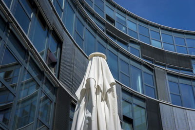 Closed parasol against modern office building