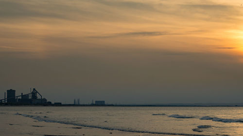 Scenic view of beach against sky during sunset