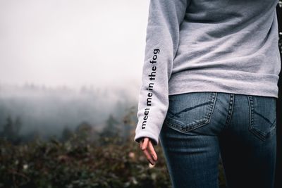 Midsection of woman standing with text on t-shirt