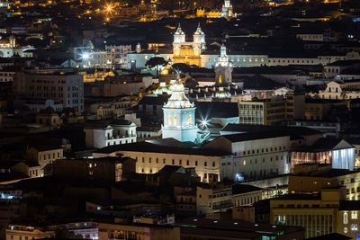 Aerial view of illuminated churches and buildings in city at night