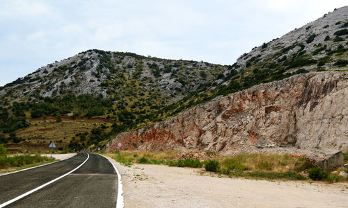 Road by mountain against sky