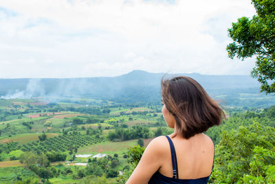 Rear view of woman standing against landscape