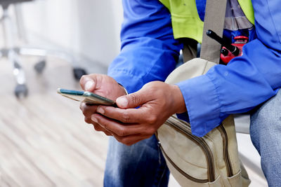 Midsection of man using mobile phone