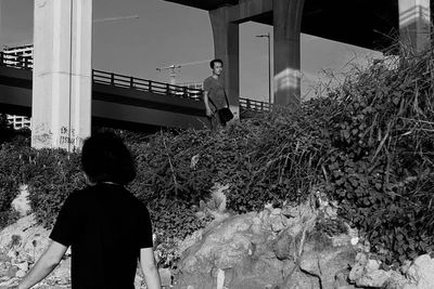 Rear view of people standing by plants