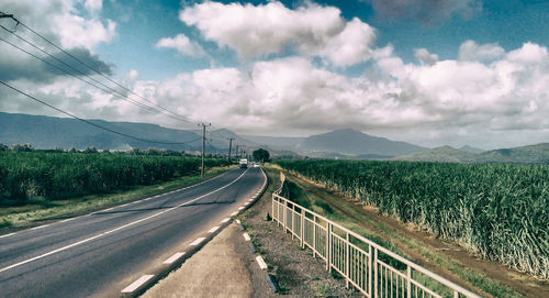 Road leading towards mountain against sky