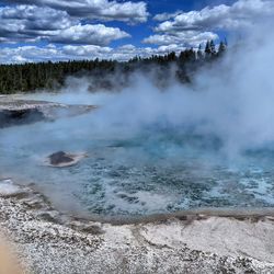 Scenic view of steam rising from hot springs on a clear, spring day in yellowstone national park