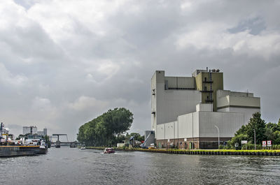 Dutch canal with factory, trees and barges