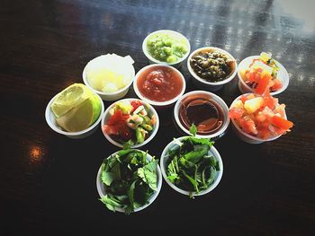 High angle view of taco ingredients in containers on table