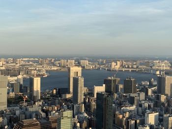 High angle view of city buildings against cloudy sky