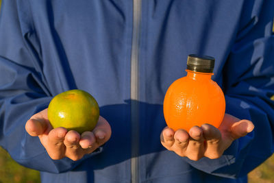 Close-up of man holding orange