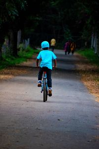 Kid riding bmx through the park on a fine evening 