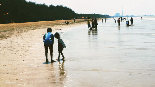 Rear view of people walking in water