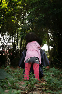 Rear view of women on street amidst trees